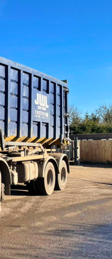 JWL Services Ltd skip lorry in action, prominently featuring the JWL logo on its side, showcasing efficient waste removal services in Essex.